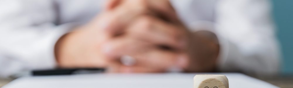 Customer service and support conceptual image - people icon on a wooden dice in front of a businessman sitting at his desk.
