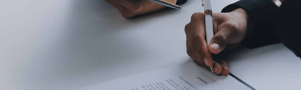 Justice and Law concept. Legal counsel presents to the client a signed contract with gavel and legal law or legal having team meeting at law firm in background